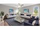 Inviting living room featuring a ceiling fan, stylish sofas, and a modern glass coffee table at 11225 Flower Ave, Weeki Wachee, FL 34613