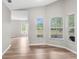 Bright, airy living room with hardwood floors and plenty of natural light from three large windows at 11225 Flower Ave, Weeki Wachee, FL 34613