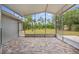 Covered and screened patio with pavers and a view of the verdant backyard at 11225 Flower Ave, Weeki Wachee, FL 34613