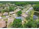 An aerial view shows a neighborhood with mature trees and well-maintained homes and landscaping at 11628 Aspenwood Dr, New Port Richey, FL 34654