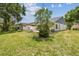 An expansive backyard features mature trees, a verdant lawn, and lush landscaping at 11628 Aspenwood Dr, New Port Richey, FL 34654