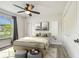 This bedroom features hardwood floors, a ceiling fan, and bright natural light from the window at 11628 Aspenwood Dr, New Port Richey, FL 34654