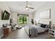 Bedroom with serene decor, ceiling fan, and ample natural light from the large window at 11628 Aspenwood Dr, New Port Richey, FL 34654