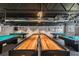 Well lit game room featuring two shuffleboard tables and multiple billiard tables at 11628 Aspenwood Dr, New Port Richey, FL 34654
