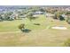 An aerial view of a golf course fairway leading to the green, surrounded by trees and sand traps at 11628 Aspenwood Dr, New Port Richey, FL 34654