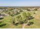 Aerial view of a golf course with several players, surrounded by trees, a pond and manicured lawns at 11628 Aspenwood Dr, New Port Richey, FL 34654