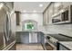Modern kitchen features stainless steel appliances, gray cabinets, and stone countertops at 11628 Aspenwood Dr, New Port Richey, FL 34654