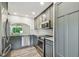 Modern kitchen with stainless steel appliances, gray cabinets, and stone countertops at 11628 Aspenwood Dr, New Port Richey, FL 34654