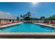 Outdoor pool with crystal-clear water, surrounded by lounge chairs and a white fence for relaxing poolside at 11628 Aspenwood Dr, New Port Richey, FL 34654