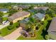 Aerial view of a well-maintained home with lush landscaping, a brick driveway, and a serene neighborhood setting at 11813 Crawford Parrish Ln, Parrish, FL 34219