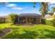 A well-maintained backyard featuring a screened-in lanai and lush green lawn at 11813 Crawford Parrish Ln, Parrish, FL 34219