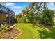 Lush backyard showcasing tropical landscaping and a meticulously maintained lawn at 11813 Crawford Parrish Ln, Parrish, FL 34219