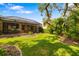 Expansive backyard features a screened lanai, lush lawn, and mature trees at 11813 Crawford Parrish Ln, Parrish, FL 34219