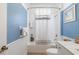 Bright bathroom features a shower-tub combo, white vanity, and blue accent wall at 11813 Crawford Parrish Ln, Parrish, FL 34219