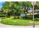 View of community sign surrounded by mature trees, flowering bushes and green lawn at 11813 Crawford Parrish Ln, Parrish, FL 34219