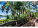 Community wooden walkway leads to picturesque lake view surrounded by lush tropical foliage and mature trees at 11813 Crawford Parrish Ln, Parrish, FL 34219