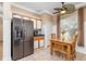 Cozy kitchen featuring stainless steel refrigerator and a dining table illuminated by a unique ceiling fan at 11813 Crawford Parrish Ln, Parrish, FL 34219