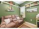 Cozy living room features a comfortable couch, decorative shelves, and tranquil green walls at 11813 Crawford Parrish Ln, Parrish, FL 34219