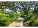 View of scenic community walking path winding through lush greenery with mature trees and tropical foliage at 11813 Crawford Parrish Ln, Parrish, FL 34219