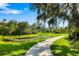 Scenic walking path alongside a pond with lily pads, shaded by mature trees and Spanish moss at 11813 Crawford Parrish Ln, Parrish, FL 34219
