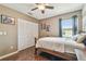 Well-lit bedroom with hardwood floors, a closet, and a window that offers a view of the outdoors at 12102 Steppingstone Blvd, Tampa, FL 33635