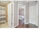 Hallway view with wood floors connecting bathroom with tile flooring and bedroom with ceiling fan at 12102 Steppingstone Blvd, Tampa, FL 33635