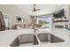 Modern kitchen features a dual sink and an open view to a living room and pool area at 12102 Steppingstone Blvd, Tampa, FL 33635