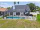 Aerial view of a screened pool and spa, a fenced yard, and palm trees at 12102 Steppingstone Blvd, Tampa, FL 33635