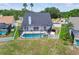 Aerial view of a screened pool and spa, fenced yard and palm trees in a suburban neighborhood at 12102 Steppingstone Blvd, Tampa, FL 33635