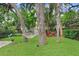 Lush backyard featuring mature trees, a hammock, lawn furniture and green grass at 1213 E Idlewild Ave, Tampa, FL 33604