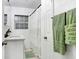 Clean, well-lit bathroom featuring a vanity, shower with curtain, and fresh green towels at 1213 E Idlewild Ave, Tampa, FL 33604