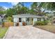 Charming light-blue home with well-manicured lawn, stone pathway, and inviting front porch area at 1213 E Idlewild Ave, Tampa, FL 33604