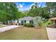 Charming light-blue home with well-manicured lawn, stone pathway, and inviting front porch area at 1213 E Idlewild Ave, Tampa, FL 33604