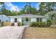 Charming light-blue home with well-manicured lawn, stone pathway, and inviting front porch area at 1213 E Idlewild Ave, Tampa, FL 33604