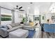 Comfortable living room featuring hardwood floors, natural light, and a large gray sectional at 1213 E Idlewild Ave, Tampa, FL 33604