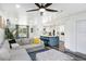 Open-concept living room showcasing a gray couch, eat-in kitchen, and modern ceiling fan at 1213 E Idlewild Ave, Tampa, FL 33604