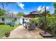 Back patio with an umbrella, dining set, and swing, surrounded by lush plants at 1213 E Idlewild Ave, Tampa, FL 33604