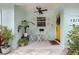 Cozy front porch with bright-yellow front door, seating area, and plants at 1213 E Idlewild Ave, Tampa, FL 33604
