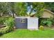Backyard shed featuring a window, greenery, and a well-maintained lawn at 1213 E Idlewild Ave, Tampa, FL 33604