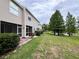 A view of the backyard of the home, with a lawn that extends to a beautiful pond with large trees at 12268 Country White Cir, Tampa, FL 33635