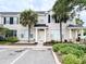 Beige townhome featuring dark shutters and palm trees enhancing curb appeal at 12268 Country White Cir, Tampa, FL 33635