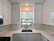 Contemporary kitchen with sleek white cabinets, stainless steel appliances, and bright natural light at 12268 Country White Cir, Tampa, FL 33635