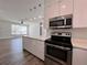 Modern kitchen with stainless steel appliances and white cabinets open to the living area at 12268 Country White Cir, Tampa, FL 33635
