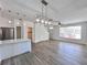 Open concept living area with light-toned wood floors, sleek lighting, open access to the kitchen, and stairway at 12268 Country White Cir, Tampa, FL 33635