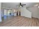 Open-concept living space boasting light wood floors, modern fan and easy access to kitchen, back yard, and stairs at 12268 Country White Cir, Tampa, FL 33635