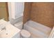 Bathroom featuring a vanity, a toilet, and a shower-tub combination with brown tile at 12488 Harper St, Spring Hill, FL 34609