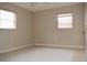 This bedroom has a tiled floor, two windows, and neutral-painted walls at 12488 Harper St, Spring Hill, FL 34609