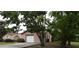 View of home's side and front showing driveway, garage, and mature landscaping at 12488 Harper St, Spring Hill, FL 34609