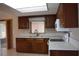Galley-style kitchen showcasing wood cabinets and white countertops and appliances at 12488 Harper St, Spring Hill, FL 34609