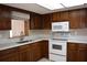 Kitchen features wood cabinets and white appliances including a microwave and oven at 12488 Harper St, Spring Hill, FL 34609